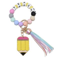 a key chain with a tassel and a pencil charm on it's side