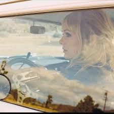 a woman sitting in the drivers seat of a car