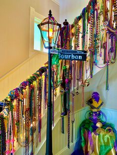 there is a street sign that says bourbon on it and lots of beads hanging from the wall