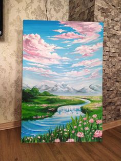 an easel painted with flowers and mountains in the background