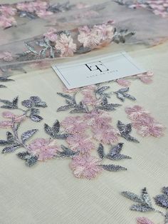 pink and grey flowers on white fabric with silver foiled letters that spell i d