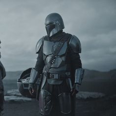 two people dressed in costumes standing next to each other on a hill with mountains in the background