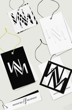 several different business cards and tags on a white surface with black and white designs, including the letter n