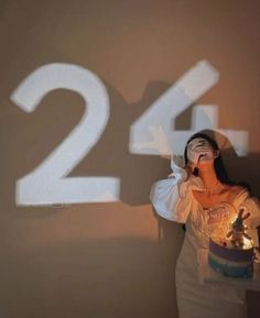 a woman standing in front of a wall with the number twenty two projected on it