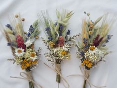 three bouquets of dried flowers tied together