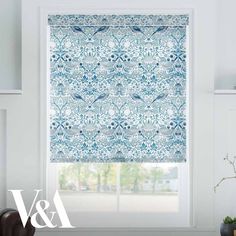 a blue and white patterned roman blind in a living room