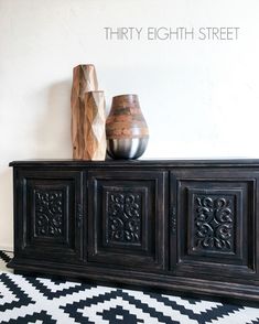 there are two vases sitting on top of this black and white cabinet, with the words thirty eight street above it