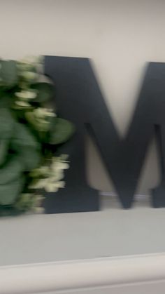 a blurry photo of flowers in front of the m and w logo on a wall