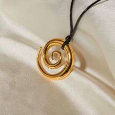 Unique Addition To Your Collection Introducing our exquisite Spiral Circle Pendant Necklace, meticulously crafted from premium stainless steel and adorned with an 18k gold plating. Designed for the modern woman, this necklace combines elegance with durability, featuring a minimalist black rope that elegantly complements any outfit. Whether you're dressing up for a gala or accessorizing for a casual day out, this necklace promises to enhance your look with its timeless appeal. Key Features Durabl Elegant Adjustable Swirl Necklace, Adjustable Spiral Gold Necklace, Adjustable Gold Spiral Necklace, Modern Gold Spiral Jewelry, Elegant Black Spiral Jewelry, Minimalist Spiral Metal Jewelry, Minimalist Gold Spiral Jewelry, Black Spiral Necklace For Gift, Spiral Black Necklace As A Gift