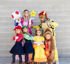 a group of people standing next to each other wearing costumes and posing for a photo