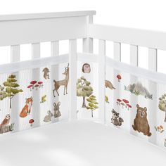 a white crib with animals and trees on it