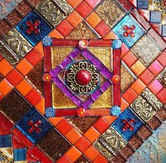 an artistic mosaic design with red, orange and blue tiles