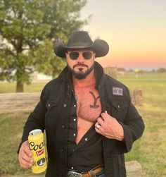 a man wearing a cowboy hat and holding a can of booze in his right hand