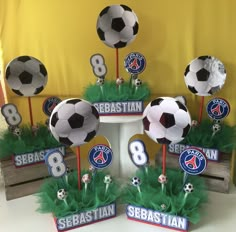 a table topped with lots of fake soccer balls and cupcakes on top of them