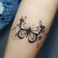 a black and white butterfly tattoo on the right arm, with flowers around its wings