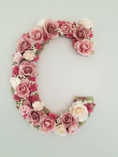 the letter q made out of flowers on a gray background with white and pink roses