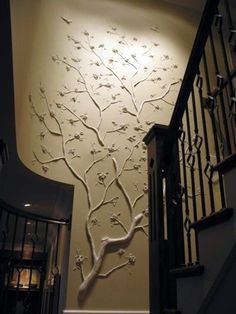 the wall is decorated with white flowers and branches, along with wrought iron railings