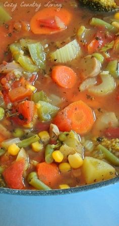 a blue pot filled with soup and vegetables