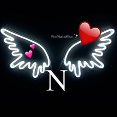 two neon wings with hearts on them and the words n in white letters, against a black background