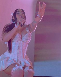 a woman in a white corset is performing on stage