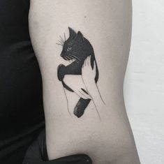 a black and white cat tattoo on the arm