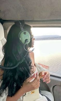 a woman with headphones on sitting in a vehicle