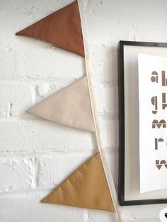 a white brick wall with some brown and tan pennants on it