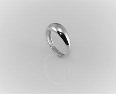 a white gold wedding ring on a plain surface, with the top edge slightly down