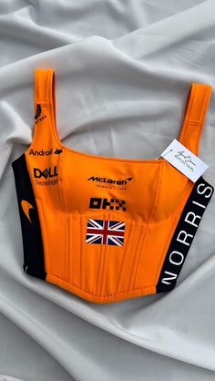 April Jean Libaton on Instagram: "How are you repping Lando Norris #4?  This one-of-a-kind Lando Norris #4 corset top was made specially for my client, tailored perfectly to her measurements ! 😍💃🧡🖤  Looking for something unique like this? I customize each piece to fit you just right—because fashion should be as unique as you are. 💖  DM me for your own personalized design or to transform your favorite merch into something stunning! 🏁✨  . . . #CustomFashion  #TailoredToYou  #F1Chic  #CorsetTop  #LandoNorris #McLaren #F1Fashion #RaceDayStyle #MotorsportChic #CorsetTop #StreetwearTransformation #FashionReimagined #F1Merch #fashionwithspeed" Mclaren Crop Top, Lando Norris Merch, Unique Clothing Pieces, Mclaren Outfit, Mclaren Aesthetic, Edgy Fits