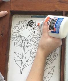 someone is painting a sunflower on a piece of wood with white paint and glue