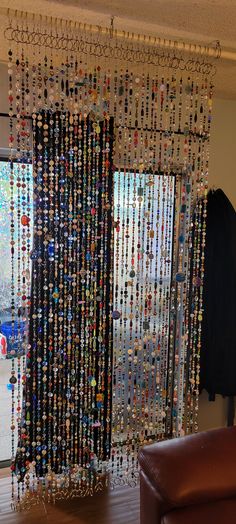 a living room filled with furniture and lots of beads hanging from the window sill