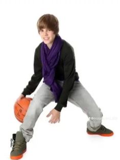 a young man is holding a basketball and posing for the camera with his hands on his hips