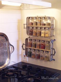 a stove top oven sitting next to a wall mounted spice rack