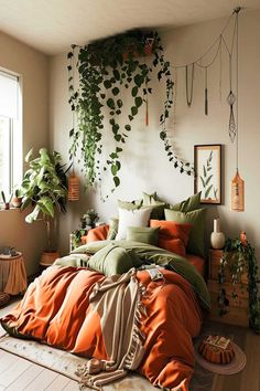 A boho chic bedroom with green and orange bedding and hanging plants. Green Orange Room Aesthetic, Dark Green Orange Aesthetic, Orange Comforter Bedroom Ideas, Forest Green And Orange Bedroom, Red And Green Bedroom Ideas, Eclectic Green Bedroom, Bedroom Orange And Green, Orange Comforter Bedroom, Orange Green Room