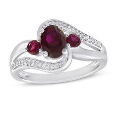 This beautiful ring springs to life with rich colorful hues. An opulent oval-cut lab-created ruby is framed with a pair of round-cut lab-created rubies creating a vibrant focal point. Graceful sweeping bands traced with bright round-cut white lab-created sapphires add extra shimmer and shine. The ring is fashioned in stylish sterling silver. Oval Ring With Lab-created Ruby And Accent Stones, Oval Birthstone Ring For Valentine's Day, Oval Jewelry With Accent Stones For Valentine's Day, Oval Ruby Birthstone Ring With Diamond Accents, Oval Center Stone Jewelry For Valentine's Day, Oval Ruby Rings With Accent Stones, Valentine's Day Oval Center Stone Jewelry, Oval Lab-created Ruby Diamond Ring With Accent Stones, Fine Jewelry Oval Lab-created Ruby Rings