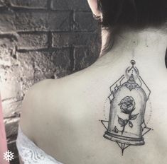 the back of a woman's neck with a bird in a cage tattoo on it