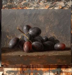 a painting of plums on a wooden surface