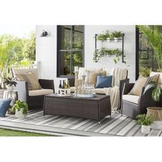 an outdoor patio with wicker furniture and potted plants