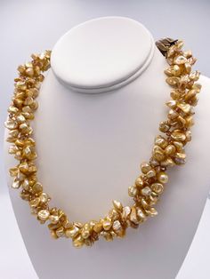 What a gorgeous statement necklace, you will glow while wearing this piece! A beautiful triple strand of top drilled golden color freshwater keshi pearls with honey colored Swarovski 3 mm bi-cone crystals. The three strands have been tightly braided together to nestle just right with each other to create this collective singular strand of pearls. Giving some mystery and intrigue into how the necklace was created.  The pearl strands are all secured inside two large decorative bronze tulip cones. Gold Multi-strand Pearl Necklace, Gold Double Strand Pearl Necklace For Jewelry Making, Gold Pearl Necklace With Polished Beads For Party, Gold Multi-strand Pearl Necklace For Party, Elegant Yellow Multi-strand Necklace, Elegant Multi-strand Amber Necklace, Gold Pear-shaped Single Strand Pearl Necklace, Handmade Multi-strand Gold Pearl Necklace, Handmade Gold Multi-strand Pearl Necklace