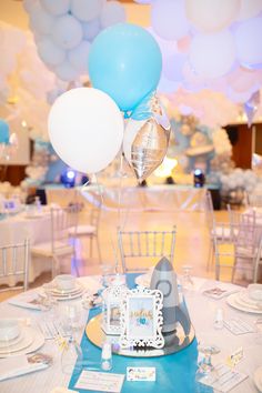 the table is set with balloons and plates