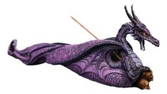 a purple dragon figurine with two sticks sticking out of it's mouth