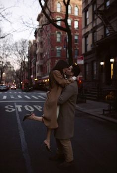 a man and woman are hugging on the street