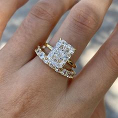 a woman's hand with a ring on top of it and a diamond in the middle