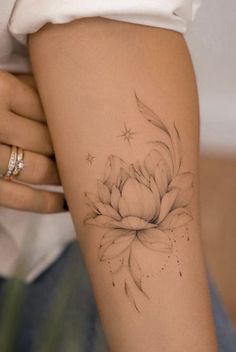 a woman's arm with a flower tattoo on the left side of her body