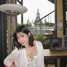 a woman standing in front of a window next to a table with food on it