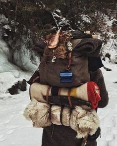 a person walking in the snow with a backpack on their back and several other items attached to them