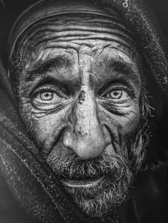 a black and white photo of an old man's face with wrinkles on it