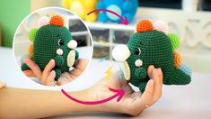 a hand holding a small green crocheted elephant with an orange hat on it's head