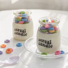 two glass jars filled with cereal candies on top of a table