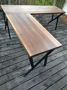 two wooden tables sitting on top of a wooden deck next to each other with black metal legs